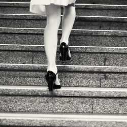 Low section of woman walking on steps