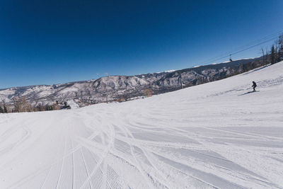 Scenic view of snowy landscape against clear blue sky