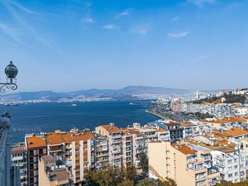 High angle view of city by sea against sky