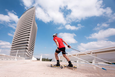 Man ski rolling on road against sky