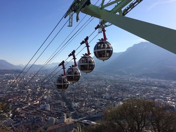 Overhead cable cars in city against sky