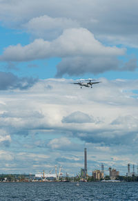 Airplane flying over sea against sky