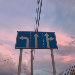 Low angle view of road sign against sky