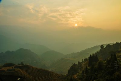 Scenic view of mountains against sky at sunset