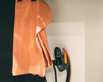 Close-up of clothes hanging on wall at home