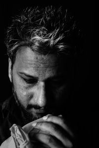 Close-up portrait of man against black background