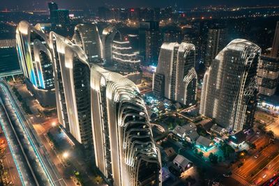 High angle view of illuminated street and buildings at night