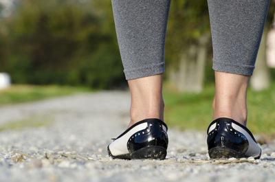 Low section of woman wearing shoes while standing outdoors