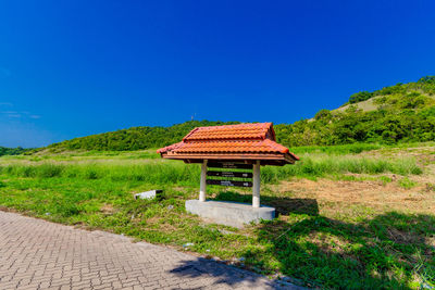 Built structure on landscape against clear blue sky