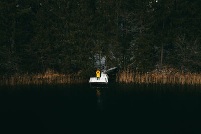 Aerial view of fishing pier with river lake around. a man in a jacket stands on the pier. cold day