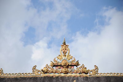 Low angle view of statue of building against cloudy sky