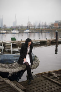 Woman standing on pier by boat