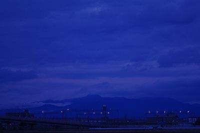 Scenic view of mountains against cloudy sky at dusk