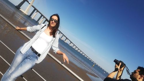 Portrait of smiling young woman against clear sky