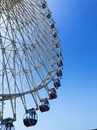 Low angle view of ferris wheel against cloudy sky