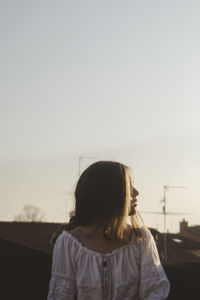 Rear view of woman standing against sky