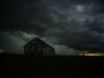 View of house against cloudy sky at night