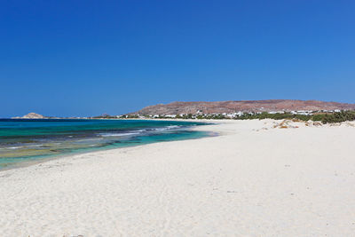 Scenic view of beach against clear blue sky