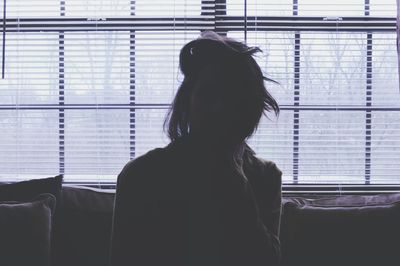 Silhouette woman at home against window