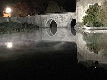 Reflection of illuminated bridge in water at night