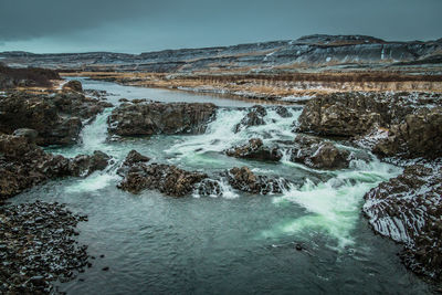 Scenic view of waterfall against sky