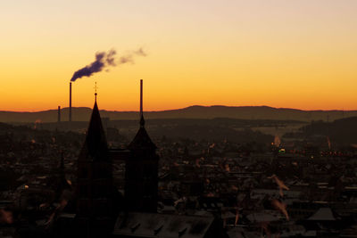 Scenic view of buildings in town against sky during sunset