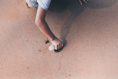 Girl collecting sand in glass at beach