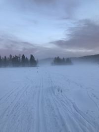 Snow covered land against sky