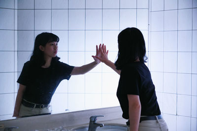 Side view of woman standing in bathroom