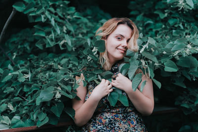 Portrait of smiling young woman holding leaves