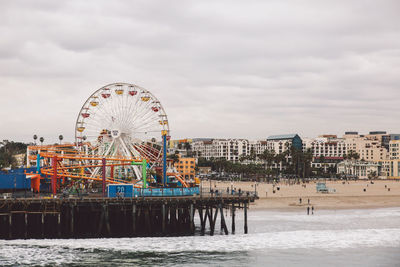 Ferris wheel at beach against sky