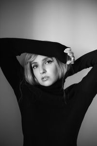 Close up portrait of a woman with pink hair and a black sweater on the background