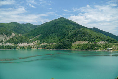 Scenic view of lake by mountains against sky