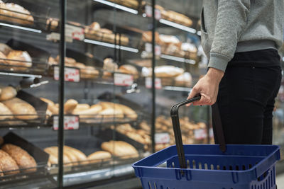 Man with shopping basket in bakery section of supermarket