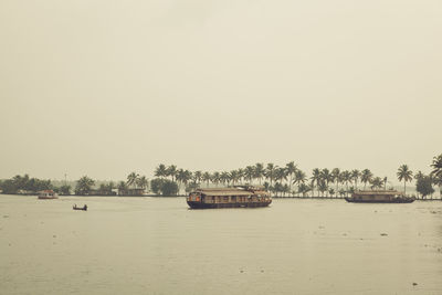 Houseboats on river against clear sky