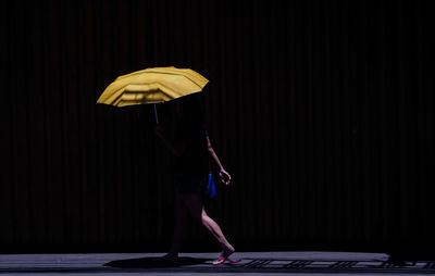 Side view of woman holding umbrella