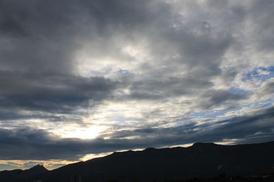 Scenic view of silhouette mountains against sky at sunset