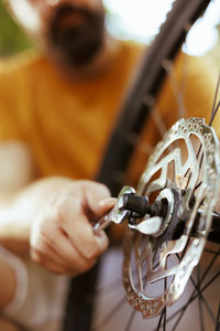 Cropped hand of man repairing bicycle