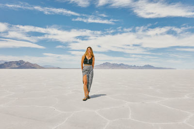 Young woman exploring bonneville salt flats during a summer road trip.