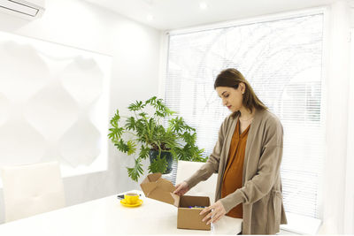 Side view of young businesswoman using digital tablet while standing in office