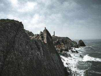 Rock formations by sea against sky