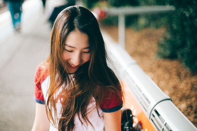 Smiling young woman sitting on railroad station