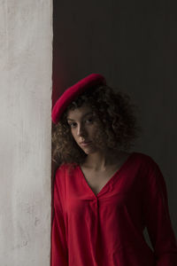 Portrait of a beautiful young woman looking away against wall