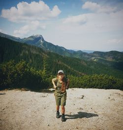 Full length of woman standing on mountain against sky