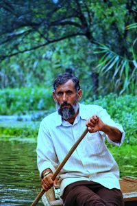 Portrait of man sitting in boat on lake