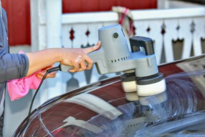 Midsection of person polishing car