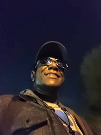 Portrait of mature man wearing sunglasses standing against sky