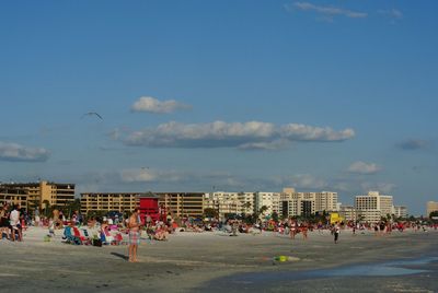 People at beach against sky