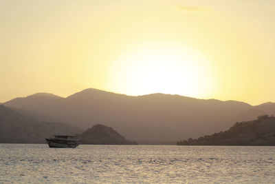 Scenic view of sea and mountains against sky during sunset