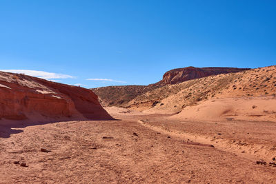 Scenic view of desert against blue sky